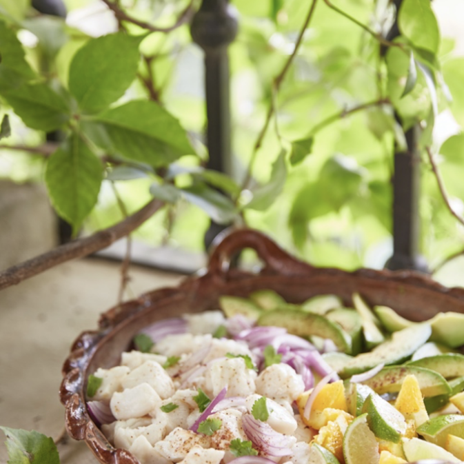 A bowl of fish and vegetables sitting on a balcony.