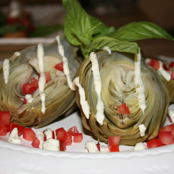 Artichokes with tomatoes and sauce on a plate.