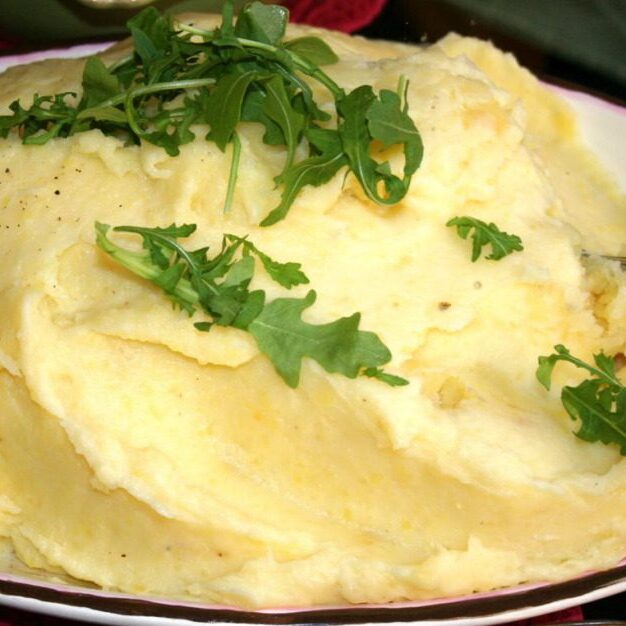 a bowl of mashed potato with a garnish