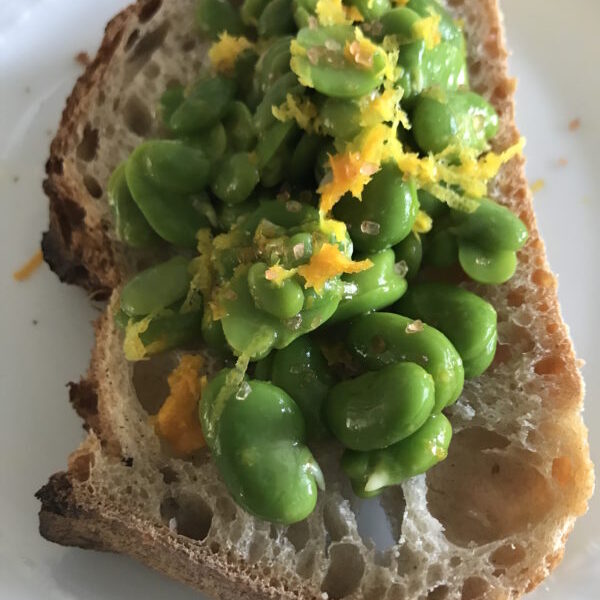 A piece of bread with green beans on it.