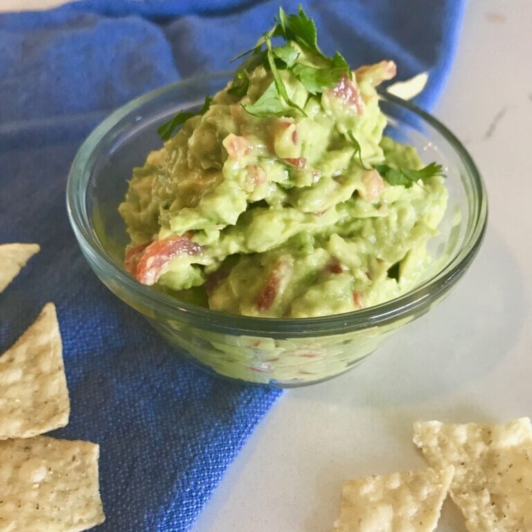 Enjoy a delicious bowl of guacamole with some crispy tortilla chips.