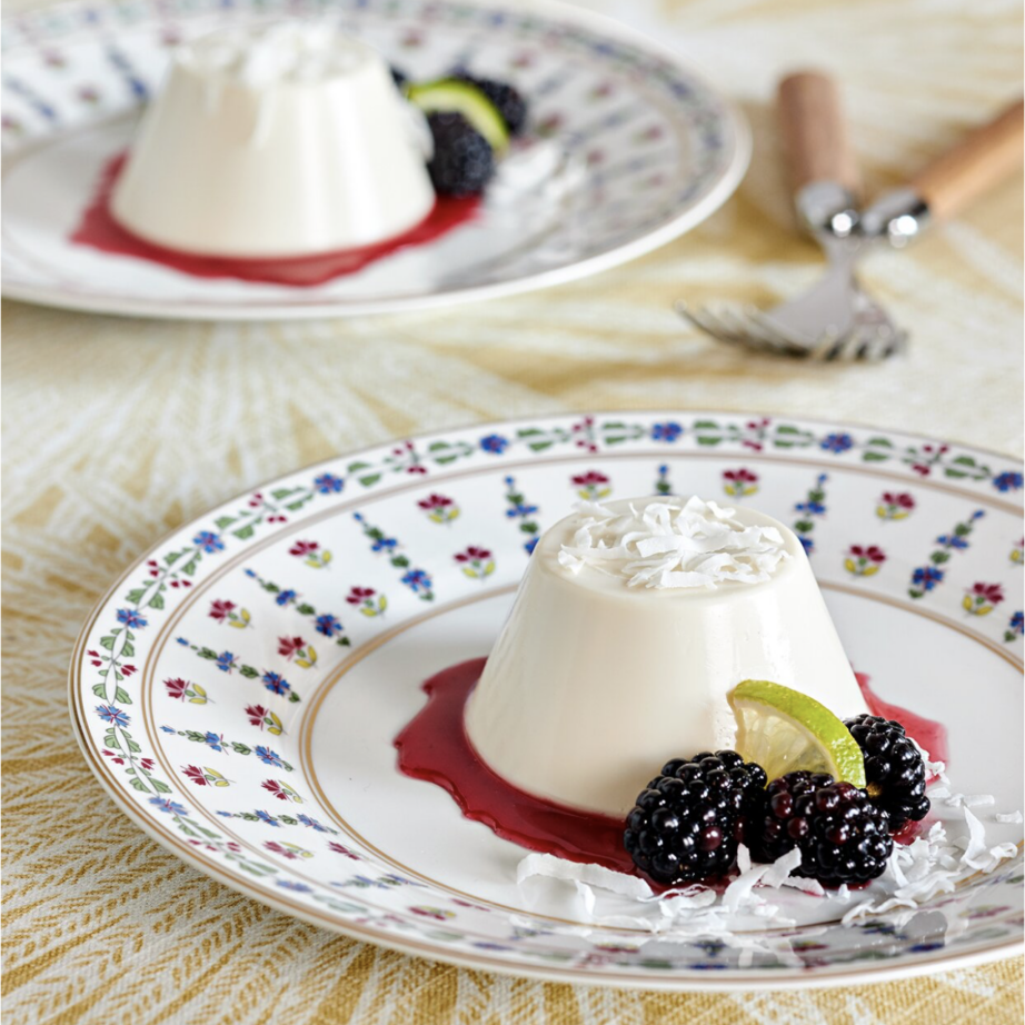 two Coconut Panna Cotta with Blackberry Sauce on plates