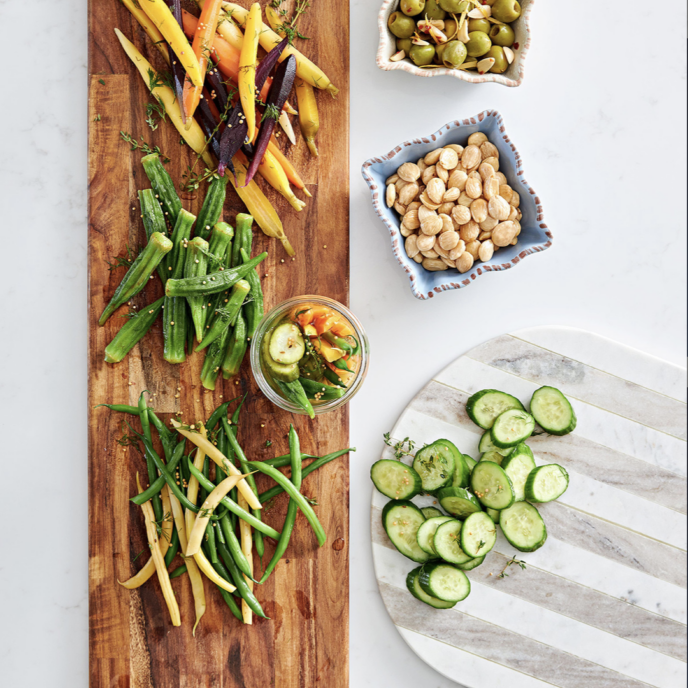 A wooden cutting board with vegetables on it.