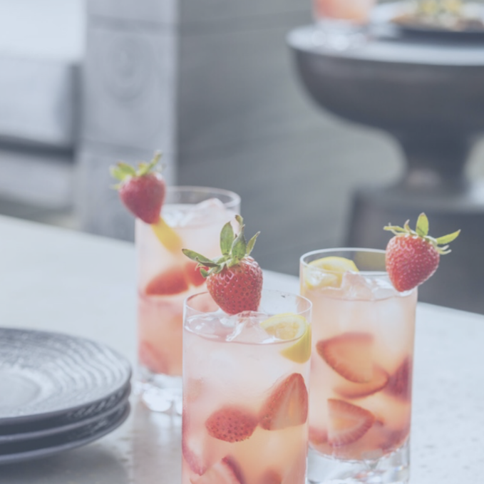 Three glasses of strawberry lemonade on a table.