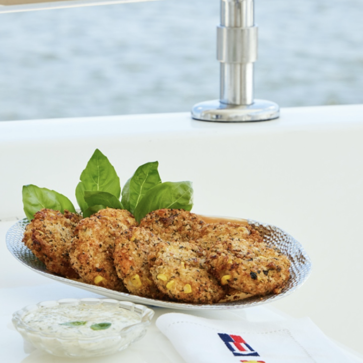 A plate of fish and chips on a table next to the water.