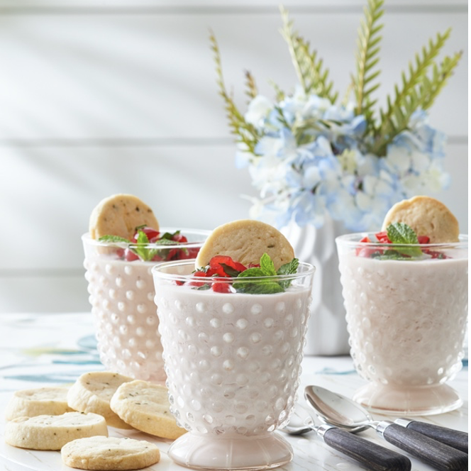 Three white cups with cookies on a plate.