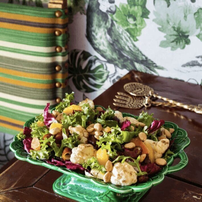 A green bowl with a salad on top of it.