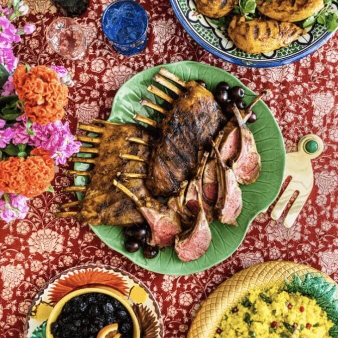 A table with plates of food and flowers.