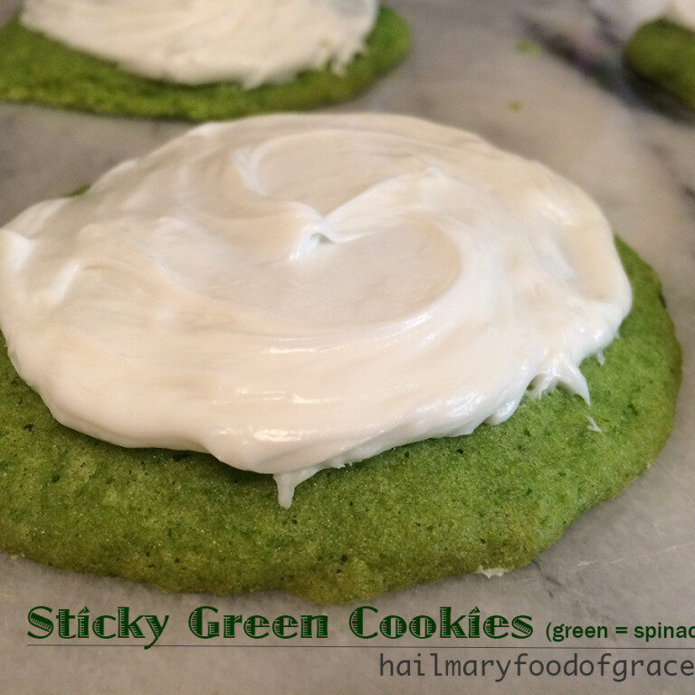 A green cookies with white frosting.