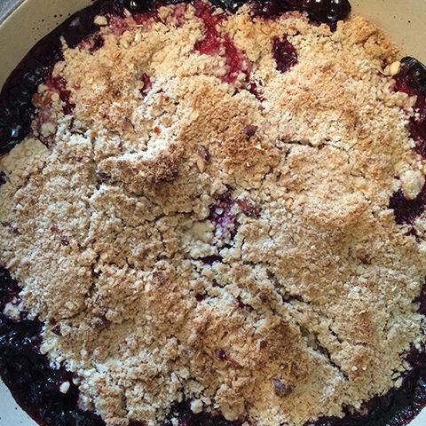 Blackberry crumble in a pan on a stove.