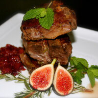 Delicious steak with cranberry sauce served on a white plate.