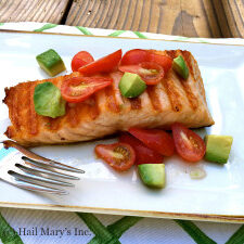 Grilled salmon with avocado on a plate.
